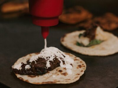 Leckere Tacos mit dunklem Fleisch und Saucen, frisch zubereitet.